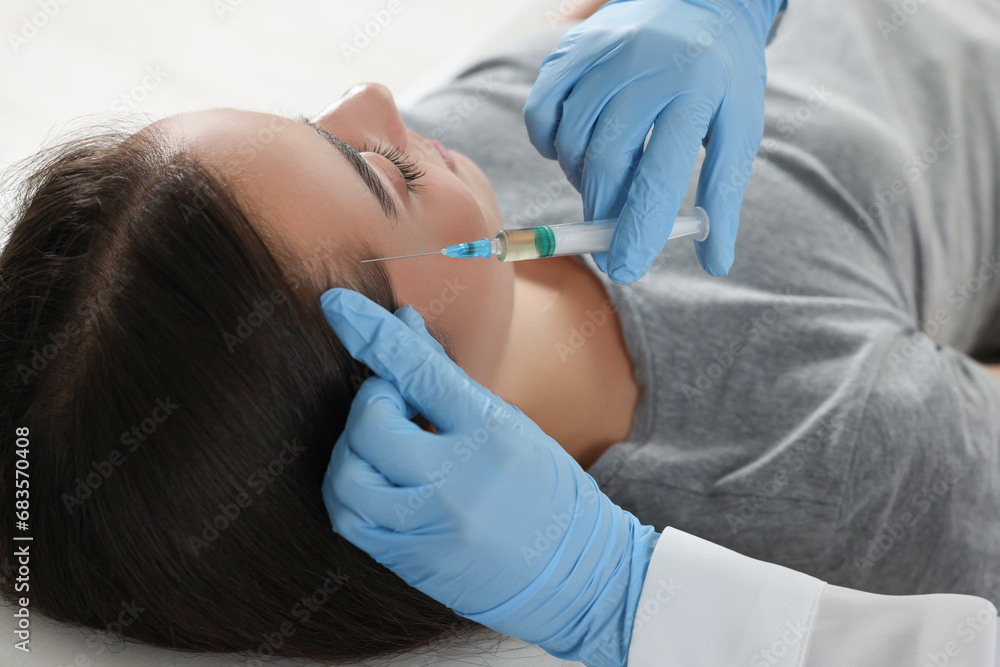 Trichologist giving injection to patient, closeup view Trichologist giving injection to patient, closeup view