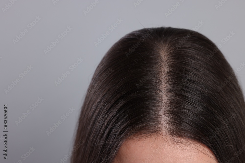 Woman with healthy hair on grey background, closeup. Space for text Woman with healthy hair on grey background, closeup. Space for text
