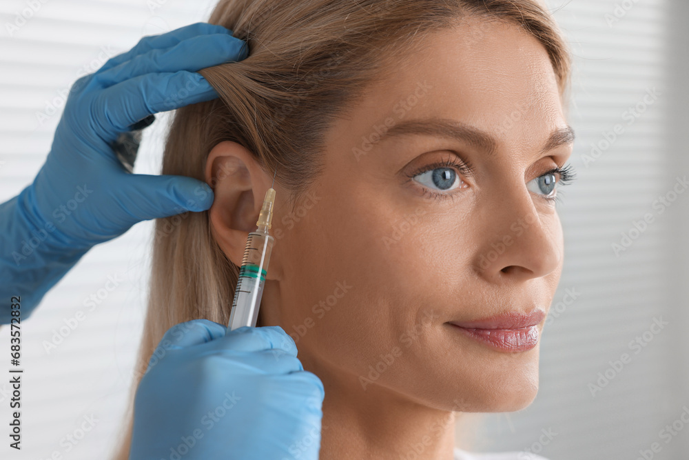 Trichologist giving injection to patient in clinic, closeup Trichologist giving injection to patient in clinic, closeup