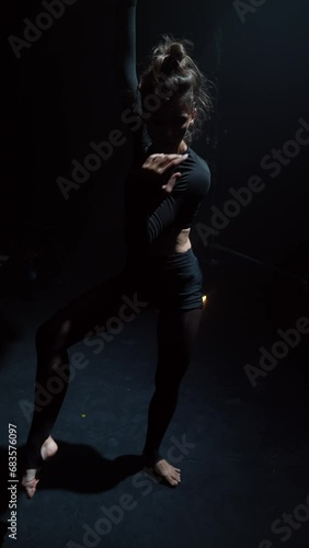 Dressed in black, she gracefully executes a contemporary dance. photo