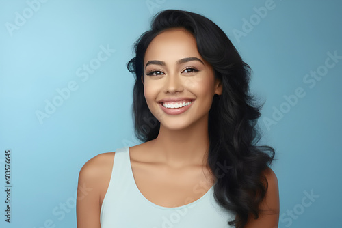 Closeup Portrait of a young beautiful asian woman smiling with her clean healthy teeth on a blue background. Dental ad. Advertising concept. Copy space