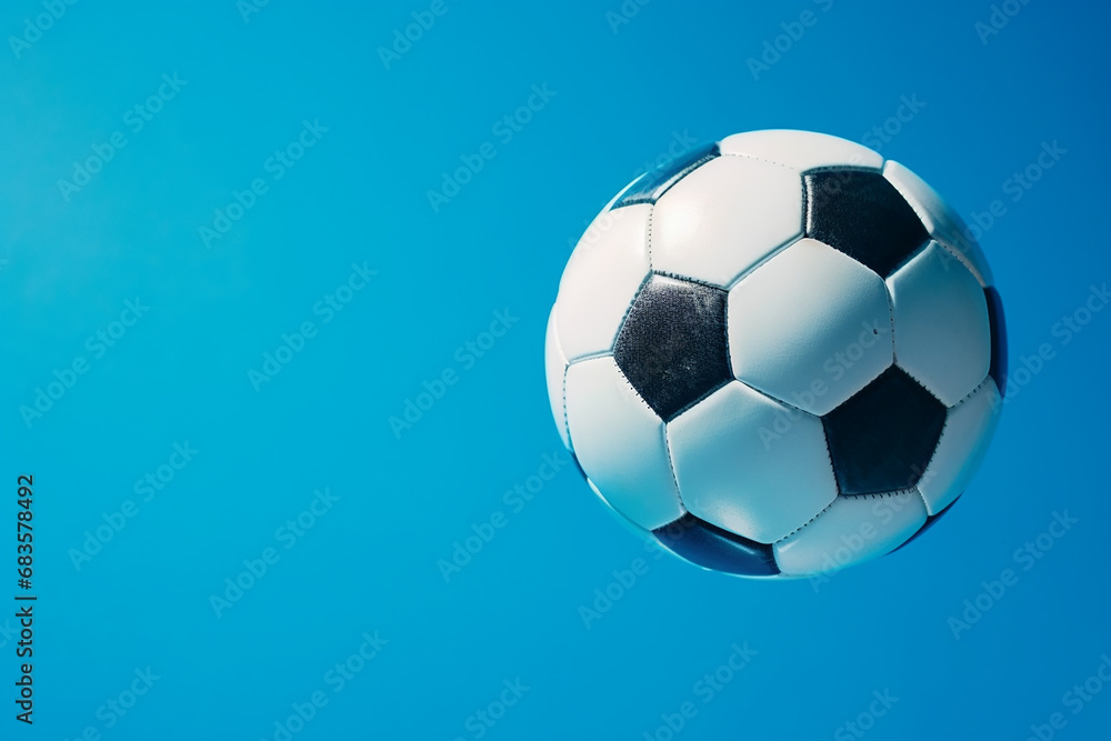 Fototapeta premium Striking Soccer Ball in Goal on Vibrant Blue Background - Created with Generative AI Tools