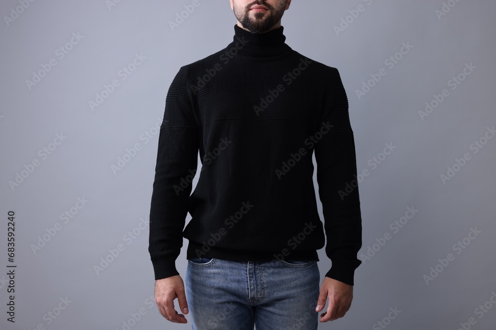 Man in stylish black sweater on grey background, closeup Man in stylish black sweater on grey background, closeup