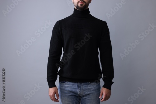 Man in stylish black sweater on grey background, closeup