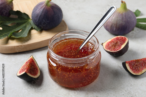 Fototapeta Naklejka Na Ścianę i Meble -  Jar with tasty fig jam and fresh fruits on white table