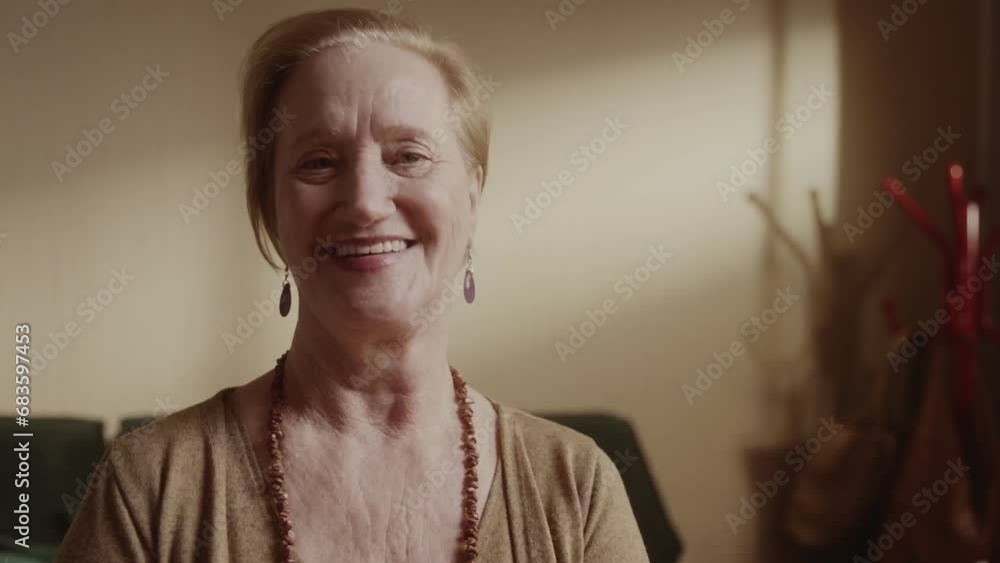 Alegre mulher sênior sorrindo sentada na cama pela manha. Cinematico 4k.