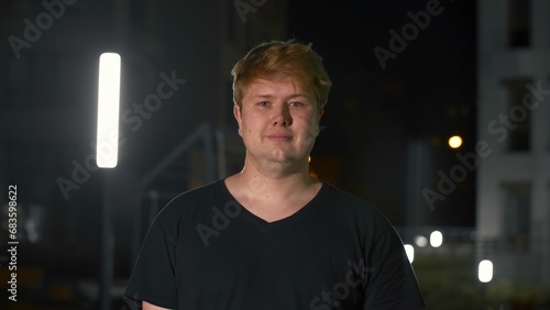 Canvas Print Young man winks with one eye in park