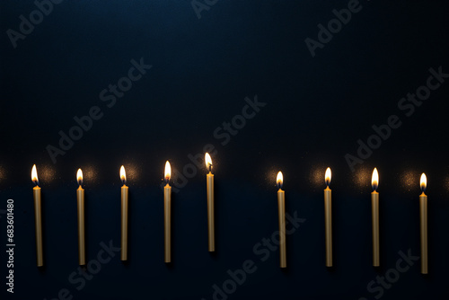 Flaming blue candles at night on dark background with stars and lights. Candles in Christian church as catholic symbol. Abstract festive backdrop. Christmas eve or Chanukah banner with copy space
