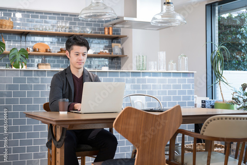 Man using computer in fashionable cafe Wide angle