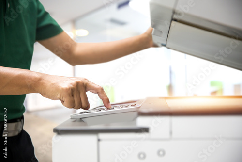 Man use copier or photocopier or photocopy scanner machine office equipment workplace for scanning document or printer for printing copy paper duplicate Xerox or service maintenance fix a problem. photo