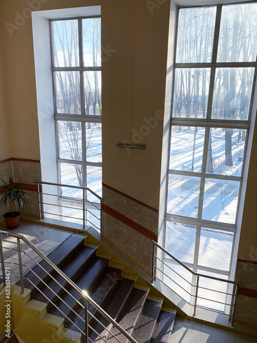 The stairs lead to the second and third floors of the hospital. Next to the stairs there are large windows facing the street. View from above