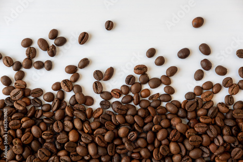Coffee beans scattered around on a white background