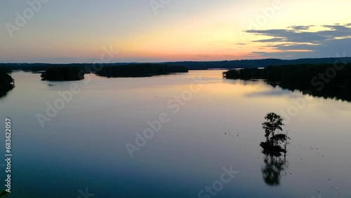 Drone footage over Loch Raven Reservoir with silhouette view of plants on lake shores at sunset, USA photo