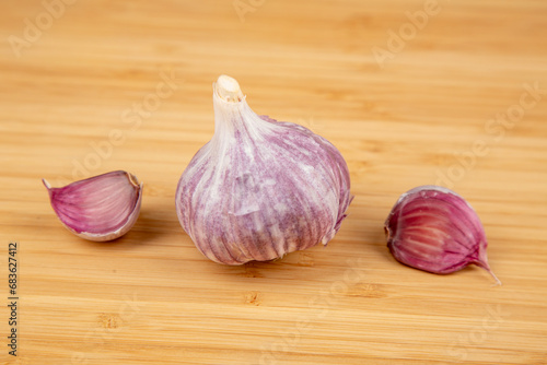 Three pieces of purple garlic on a cutting board
