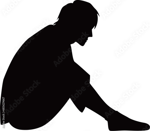 体育座りして悩む若い男性のシルエット