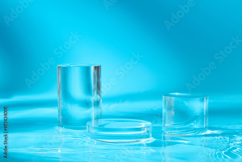 Three transparent podiums in round and cylinder shaped displayed on the water. Empty space to show your goods or beauty product