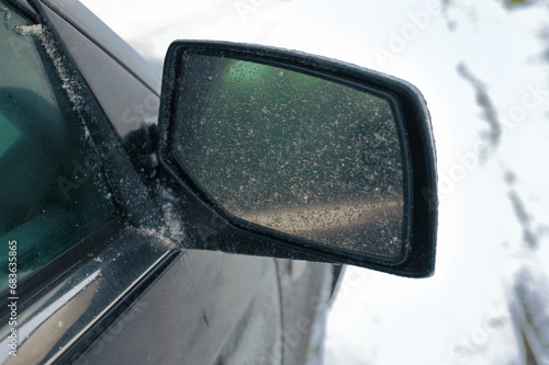 a side car mirror covered with ice  outdoor closeup