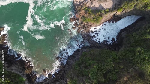 Drone view The beauty of Tanjung Karang Penganten on Gebyuran Beach or Lampon Beach, Kebumen, Central Java, Indonesia, a beach with beautiful coral cliffs, calm waves, hills and green trees photo