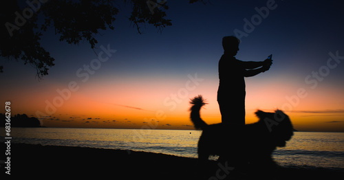 Sunset with man and dog in Seychelles beach