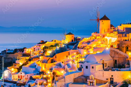 White churches an blue domes by the ocean of Oia Santorini Greece during sunset in the evening dusk