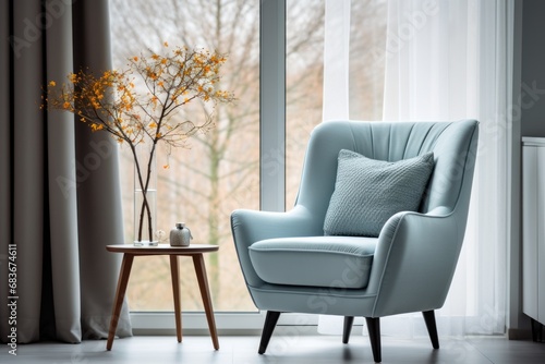 A mid-century blue armchair next to the window is decorated with white curtains.