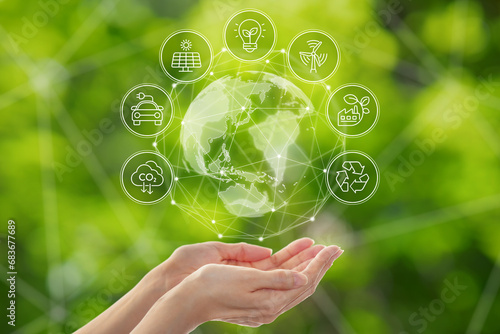 Environmental technology and Sustainable development goal (SDGs) concept. Hands holding Global communication network with Environment icon on a green background.