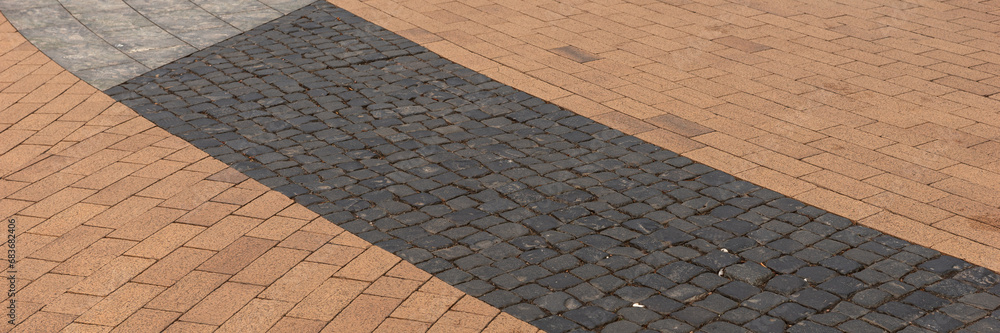 Fototapeta premium Panoramic image. New sidewalk in the city. Paving blocks made of colorful stones 