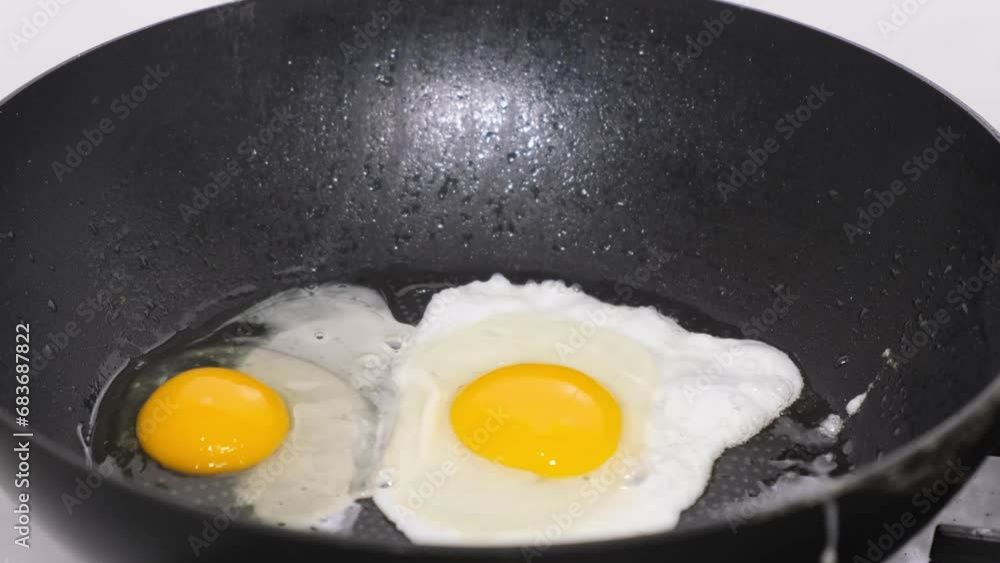 Delicious fried chicken eggs falling into the pan, close-up Delicious fried chicken eggs falling into the pan, close-up