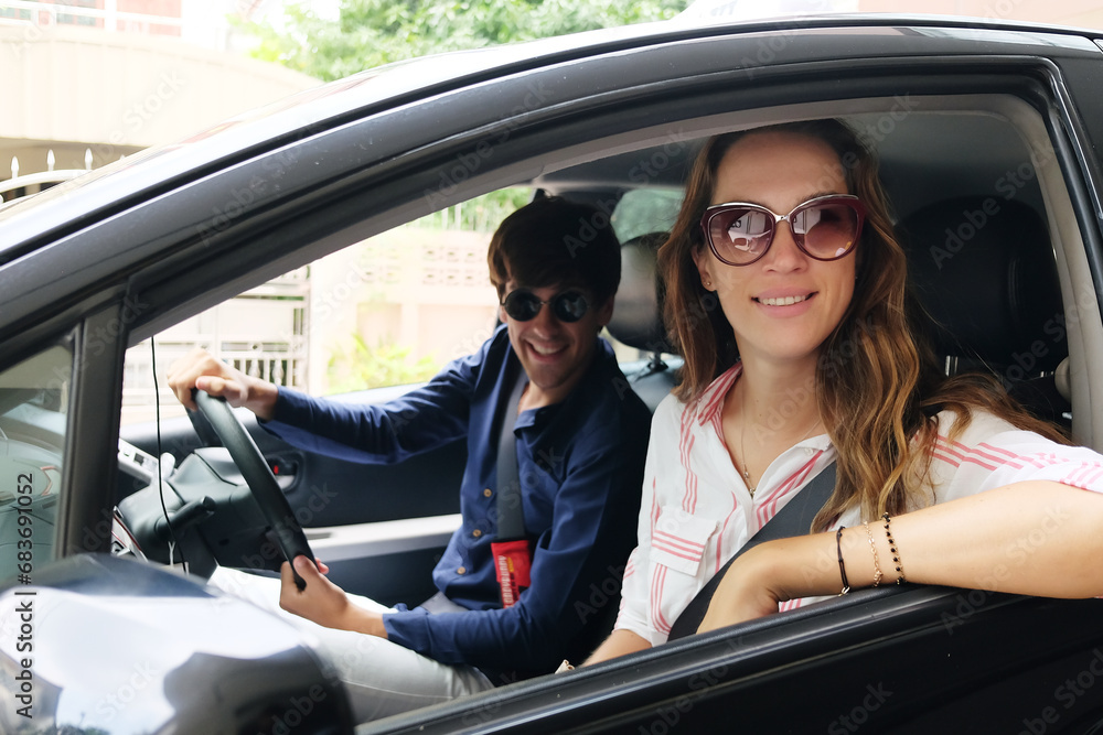 Smiling Young Caucasian traveler couple love is relaxing and Driving a car for travel on holiday. Happiness of Honeymoon trip on vacation concept Smiling Young Caucasian traveler couple love is relaxing and Driving a car for travel on holiday. Happiness of Honeymoon trip on vacation concept