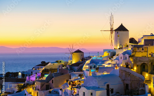 White churches an blue domes by the ocean of Oia Santorini Greece during sunset, a traditional Greek village in Santorini during summer in the evening