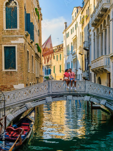 a couple of men and women on a city trip in Venice Italy sitting at a bridge in Venice  Italy. cityscape citytrip Venice Italy during summer