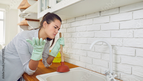 Photos Young woman having a problem with the blocked kitchen sink