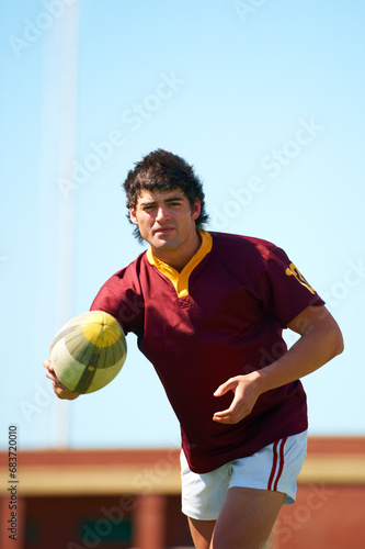 Sports, fitness and man with rugby, ball or pass at a field for training, match or hobby outdoor. Football, face and male athlete at a park for game day, performance or workout, skill or practice