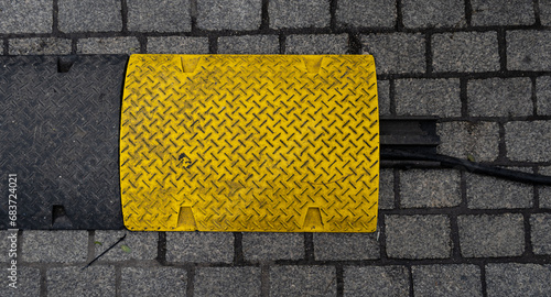 Cable protector cover. Yellow and black protective cable ramp for outdoor events. photo