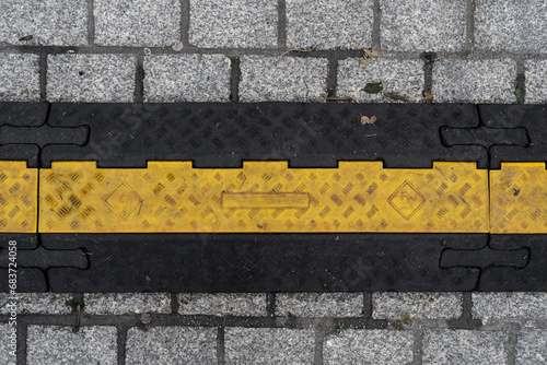 Cable protector cover. Yellow and black protective cable ramp for outdoor events. photo