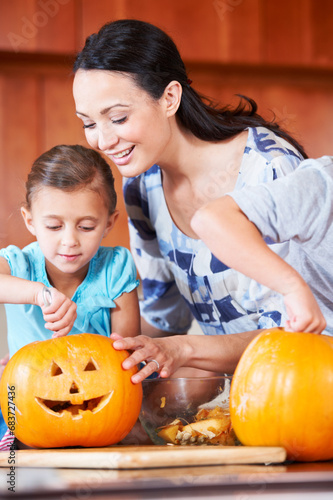 Halloween, pumpkin and mother with child in the kitchen for holiday celebration at home. Creative, smile and happy mom with girl kid bonding and carving vegetable for decoration or tradition at house