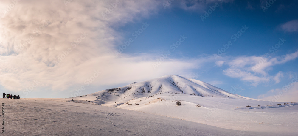 Wide angle panorama with group of hikers and the Gutansar mount in Armenia