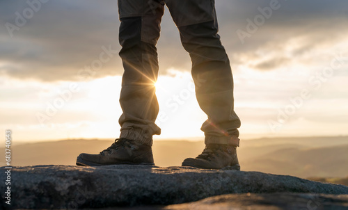 Fototapeta Naklejka Na Ścianę i Meble -  man in special boots walking in the mountains reaching the destination and on the top of mountain in Peak District at sunset on autumn day Travel Lifestyle concept