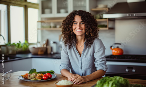 Beautiful young and healthy looking woman in the kitchen is preparing healthy food from tresh vegetables. Healthy lifestyle concept photo