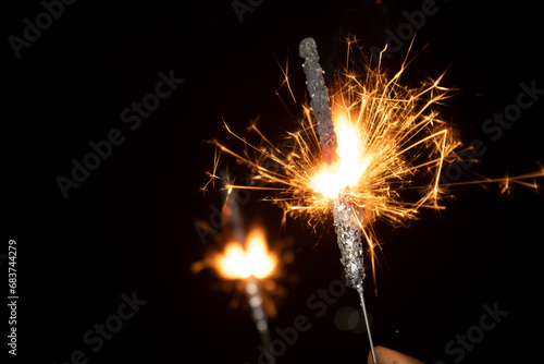 Burning sparkler in hand on black background. New year and Christmas concept