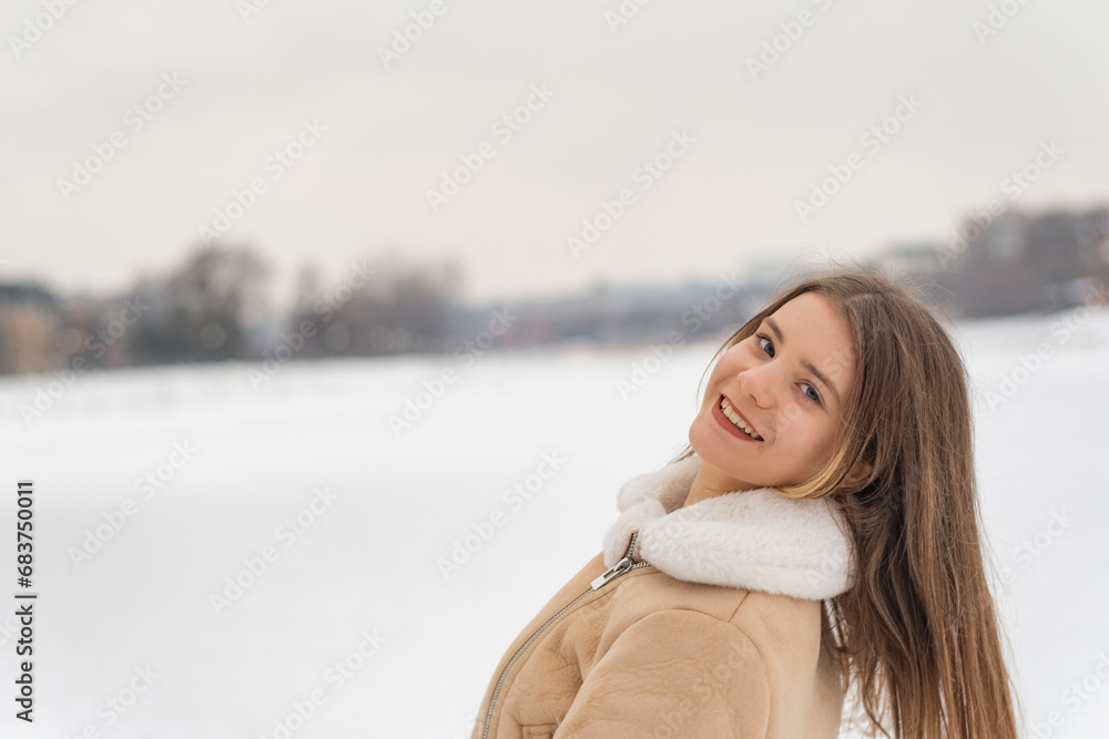 Smiling girl in trendy beige sheepskin coat have fun in snowy clearing. Woman rejoices in frosty winter day Smiling girl in trendy beige sheepskin coat have fun in snowy clearing. Woman rejoices in frosty winter day