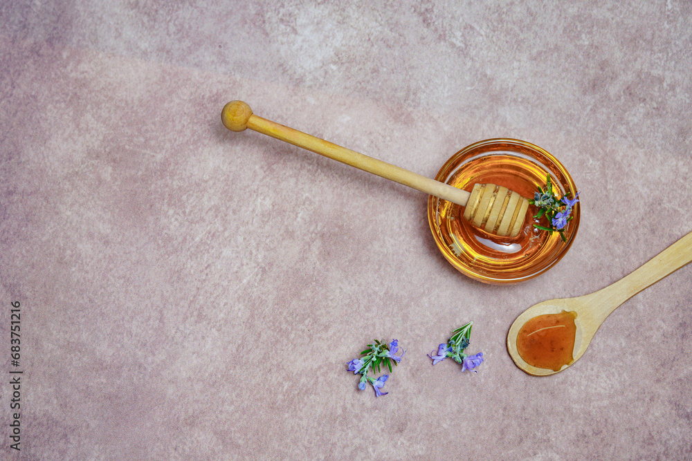 top view of natural rosemary honey in a glass bowl with a wooden spoon and fresh rosemary branches in blossom top view of natural rosemary honey in a glass bowl with a wooden spoon and fresh rosemary branches in blossom