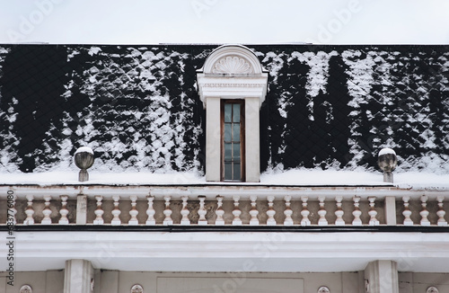 Black roof with attic and snow-covered tiled roof and white balustrade. Potocki Palace in Lviv, Ukraine. photo
