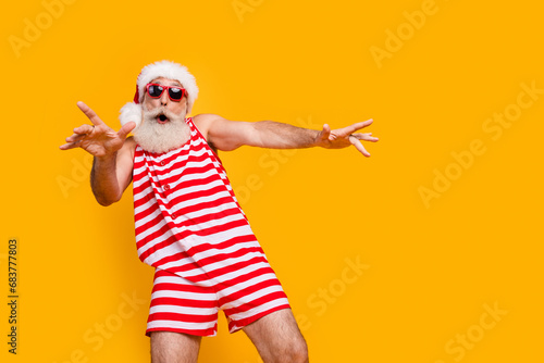 Photo of good mood carefree elderly guy wear new year swimsuit hat sunglass having disco fun empty space isolated yellow color background