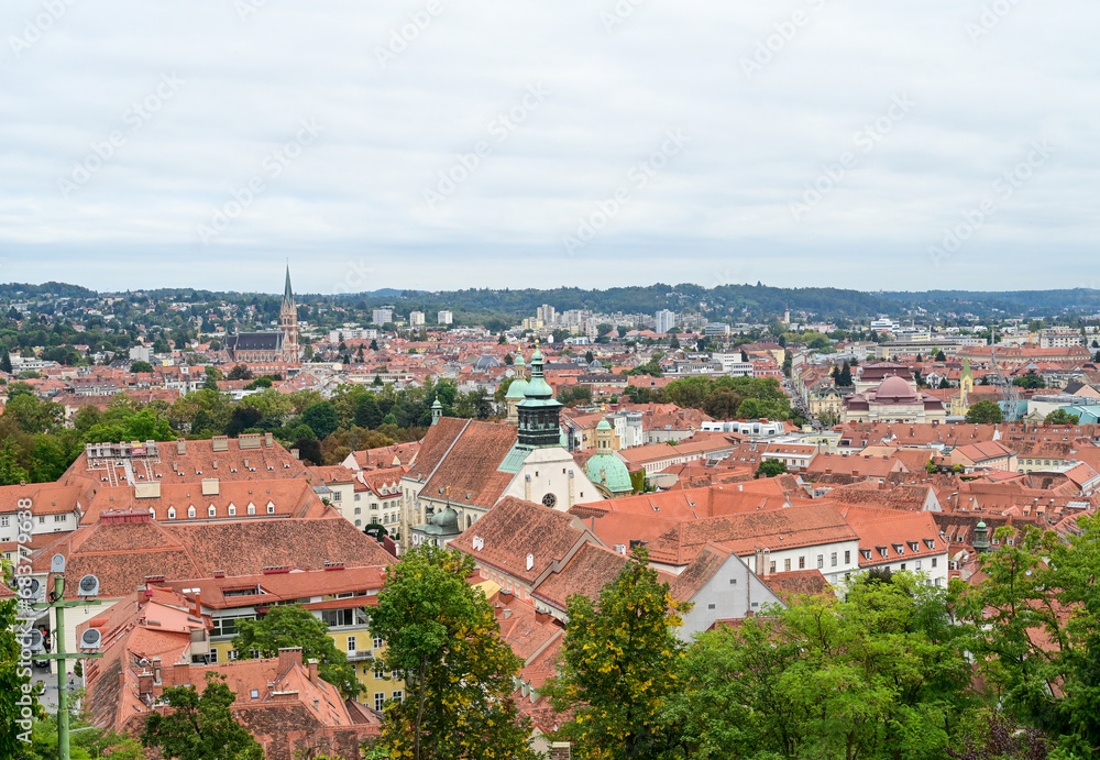 Graz, Austria: Panoramic view of the city. Buildings, houses, streets and red roofs of Graz. Old town, view from the castle. 