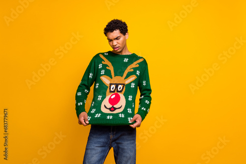 Photo of unsatisfied young person look christmas deer print sweater empty space isolated on yellow color background photo
