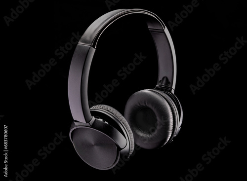 A pair of black bluetooth wireless headphones on a black background