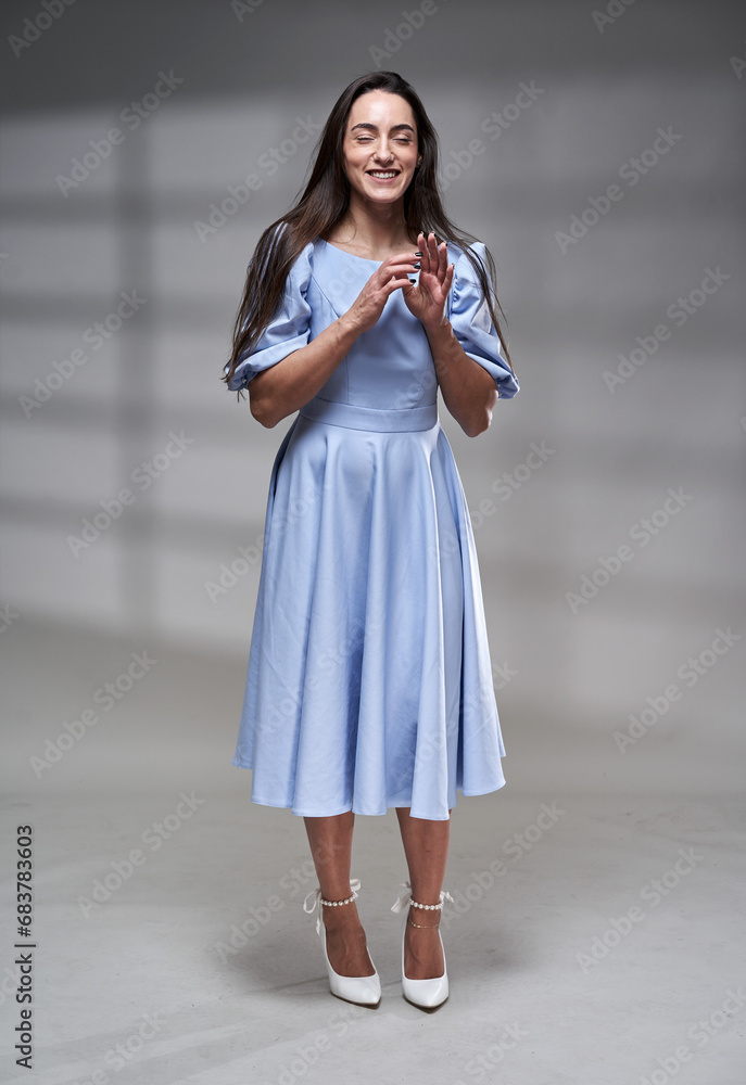 Hispanic woman in blue dress, beauty shot with window behind Hispanic woman in blue dress, beauty shot with window behind