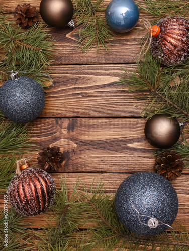 Festive template for happy winter holidays, New Year, Christmas celebration. Creative flat lay, natural pine branches, Xmas baubles on rustic wooden table background with copy space. Vertical shot