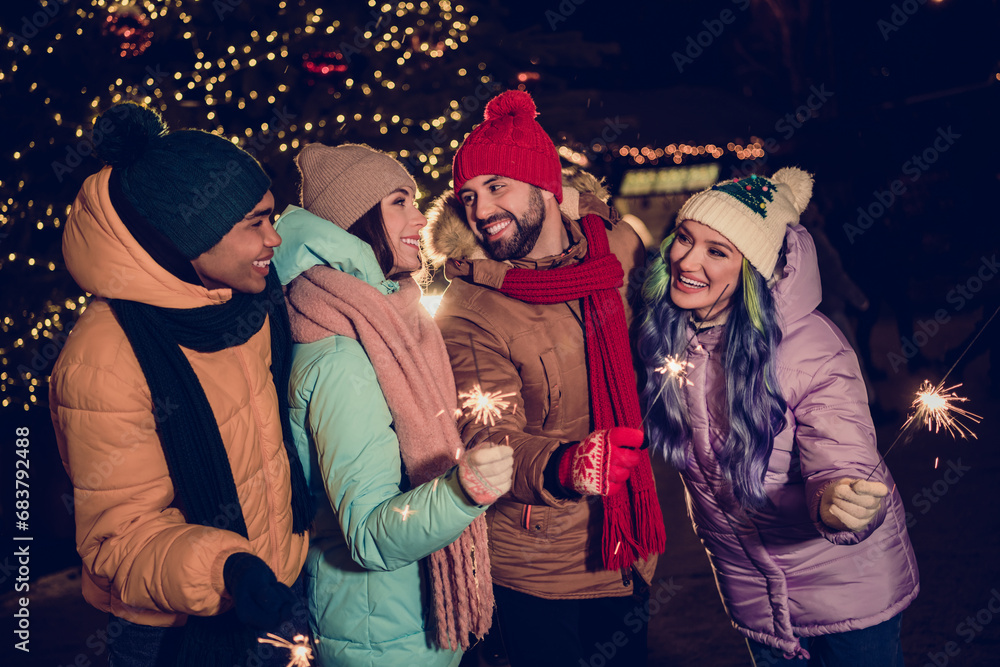 Photo of sweet dreamy two couples dressed coats enjoying midnight holding x-mas stick sparkles together outdoors urban fair park Photo of sweet dreamy two couples dressed coats enjoying midnight holding x-mas stick sparkles together outdoors urban fair park